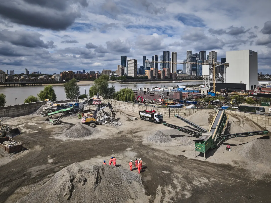 An aerial shot of Holcim's Morden Wharf Recycling Centre in London with the River Thames and the City of London in the background