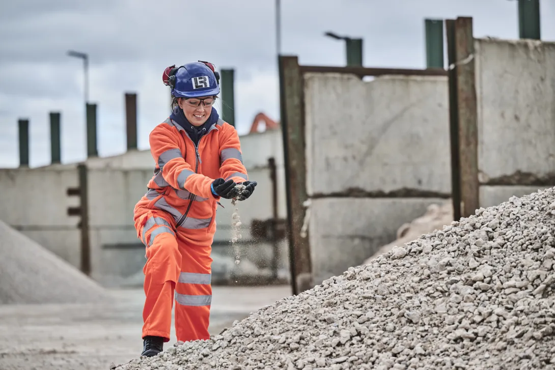 A female worker in high visibility PPE handles construction demolition materials at Holcim Land Recovery's Bordesley Green Recycling Centre