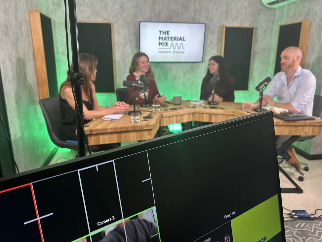 A monitor in the foreground showing what the camera is filming during the studio filming or Holcim's Material Mix podcast. The panel of guests are seated in the background.