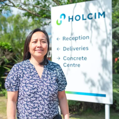 Specification Manager Anh Nguyen standing in front of a Holcim sign at Bardon Hill head offices