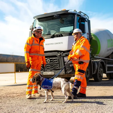 Nick, Buzzby and his colleague standing in front of a cement mixer with the plant visible in the background